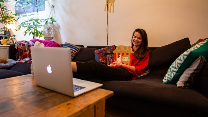 Vrouw kijkt thuis naar film thuis op de bank